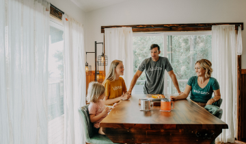 Happy family talking at breakfast table