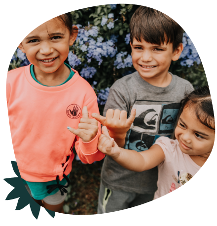 Three children giving the shaka hand gesture