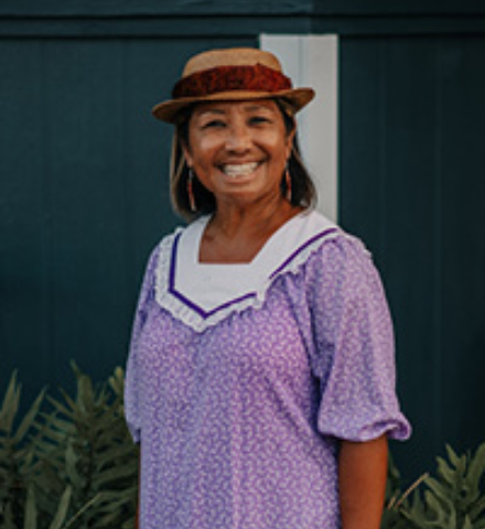Older woman smiling standing outside her home